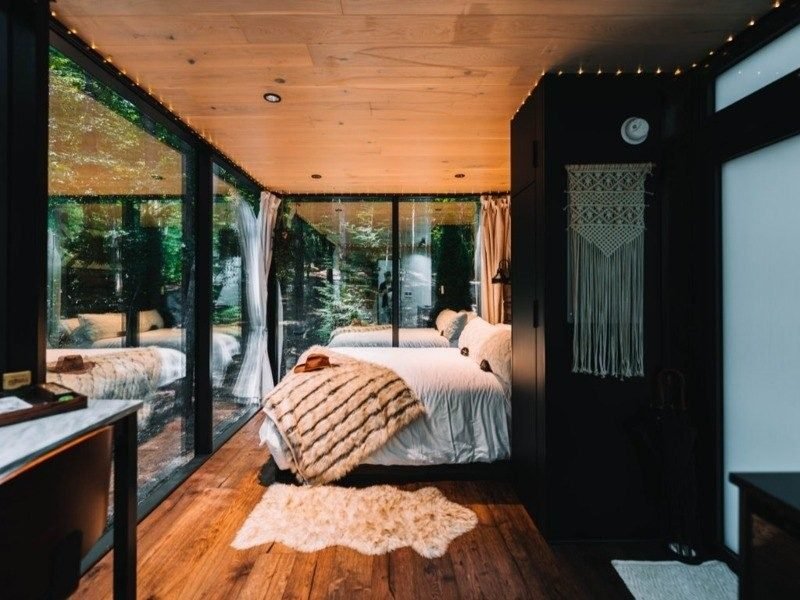 Cozy bedroom interior with fairy lights and forest views